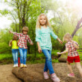 Children balancing on a log