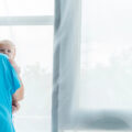 Panoramic shot of young mother holding her child in hospital