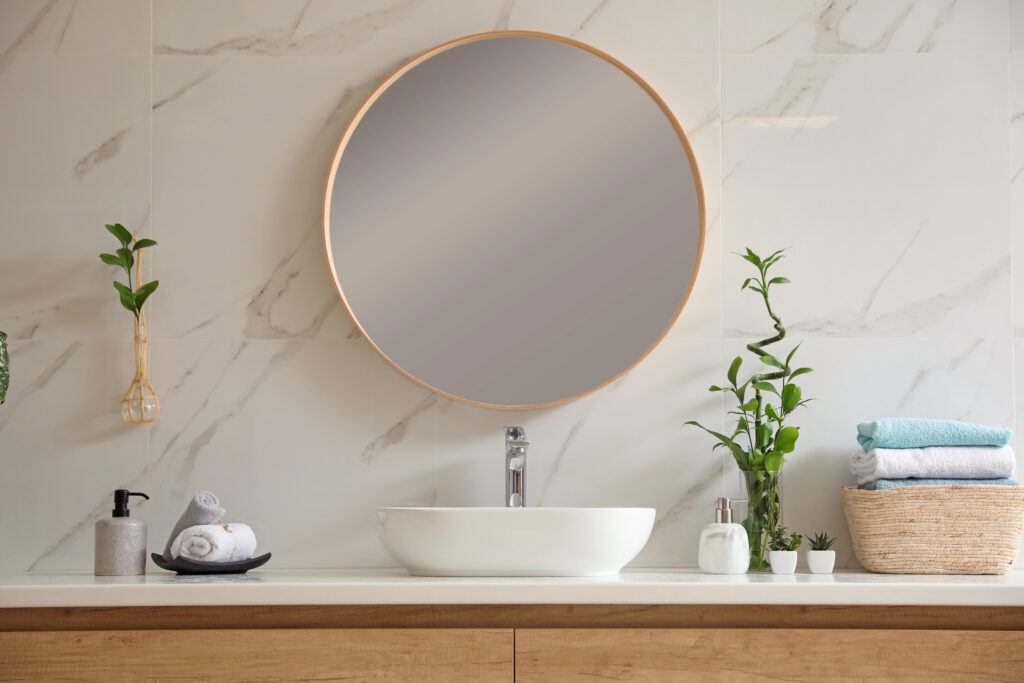 Bathroom circular mirror with gold edge above sink