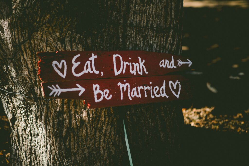 Wedding sign by oak tree 'Eat Drink and Be Married'