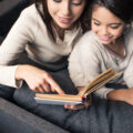 Mum and daughter looking at a book together