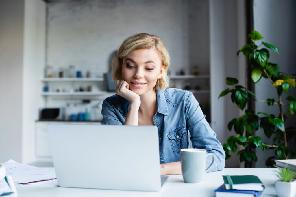 A blonde woman deep in concentration working from home as a virtual assistant
