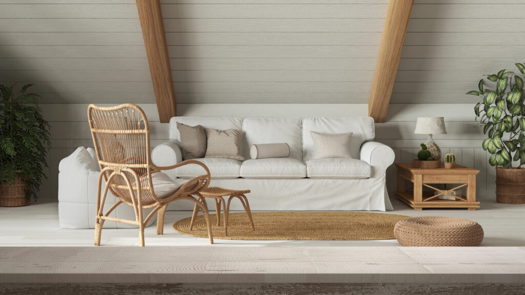 A really cool loft living room with white sofa and cushions and a laid back rattan chair with footstool to relax on