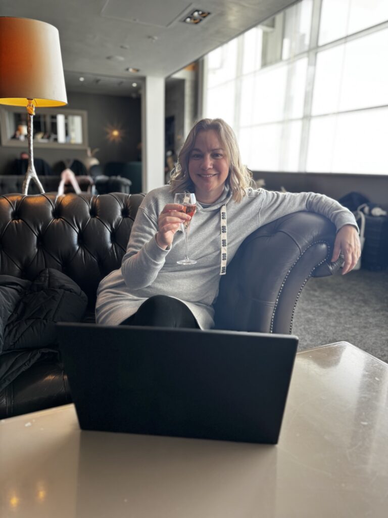 Lady looking relaxed and happy enjoying a sparkling rose at No1 lounge at Brimingham airport