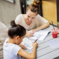 Young tutor helping girl with her studies