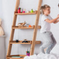 Two kids jumping on their bed laughing and having fun