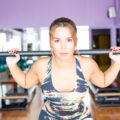 Woman focussing hard and lifting weights at the gym