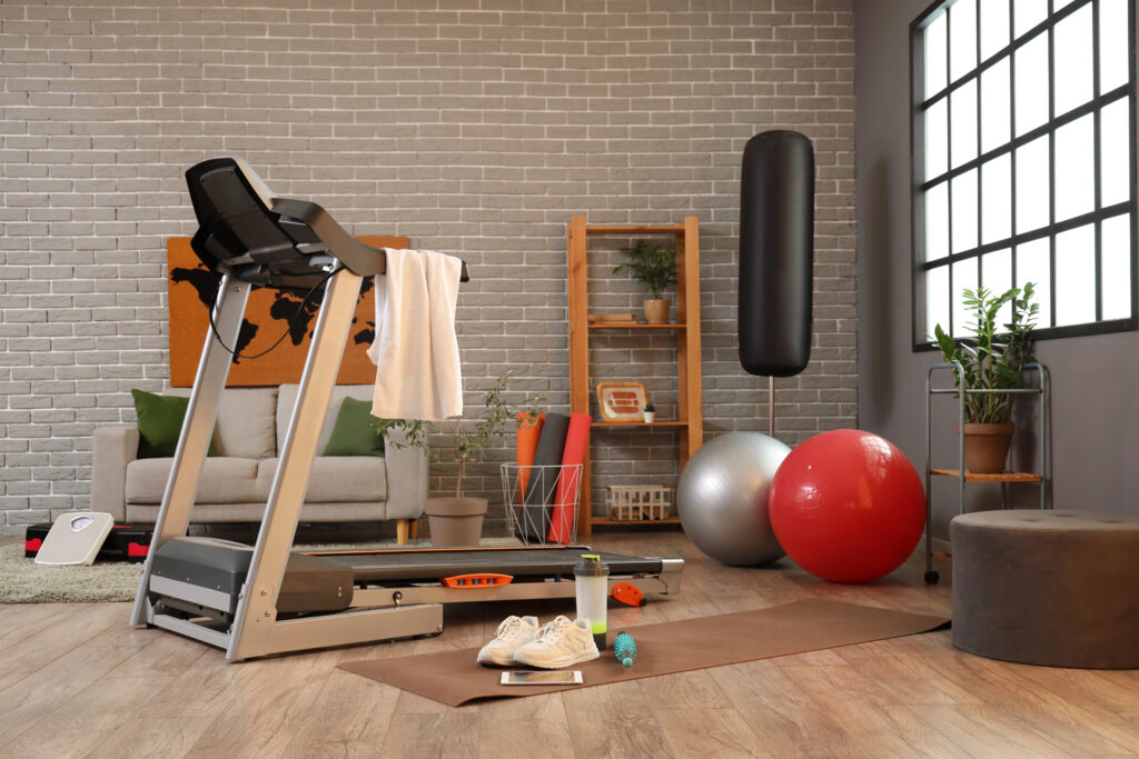 Home gym with treadmill in stylish apartment with brick walls
