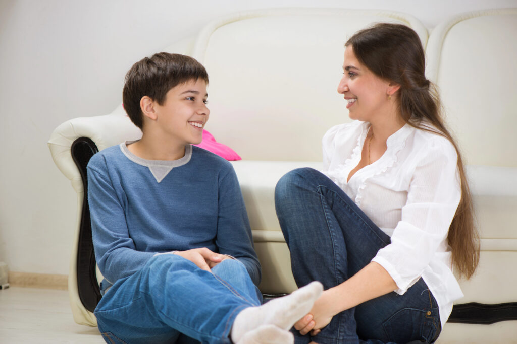 Mum and son talking to each other on the floor by the sofa positively