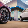 Automotive Dealership Store. New and Pre Owned Vehicles in Front of the Showroom Building.
