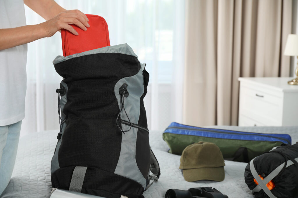 Ladies hand shown packing a rucksack ready for a hiking holiday
