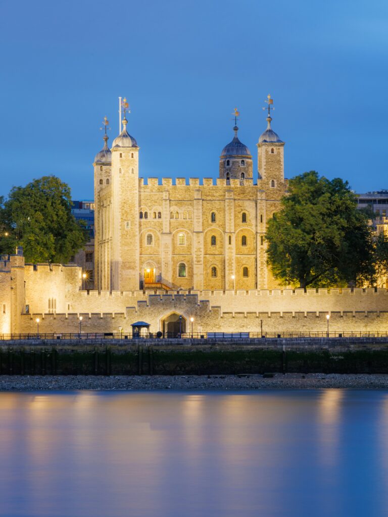 The Tower of London illuminated as night draws in -view from the Thames.