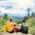 Rear view of family with small children hiking outdoors in summer
