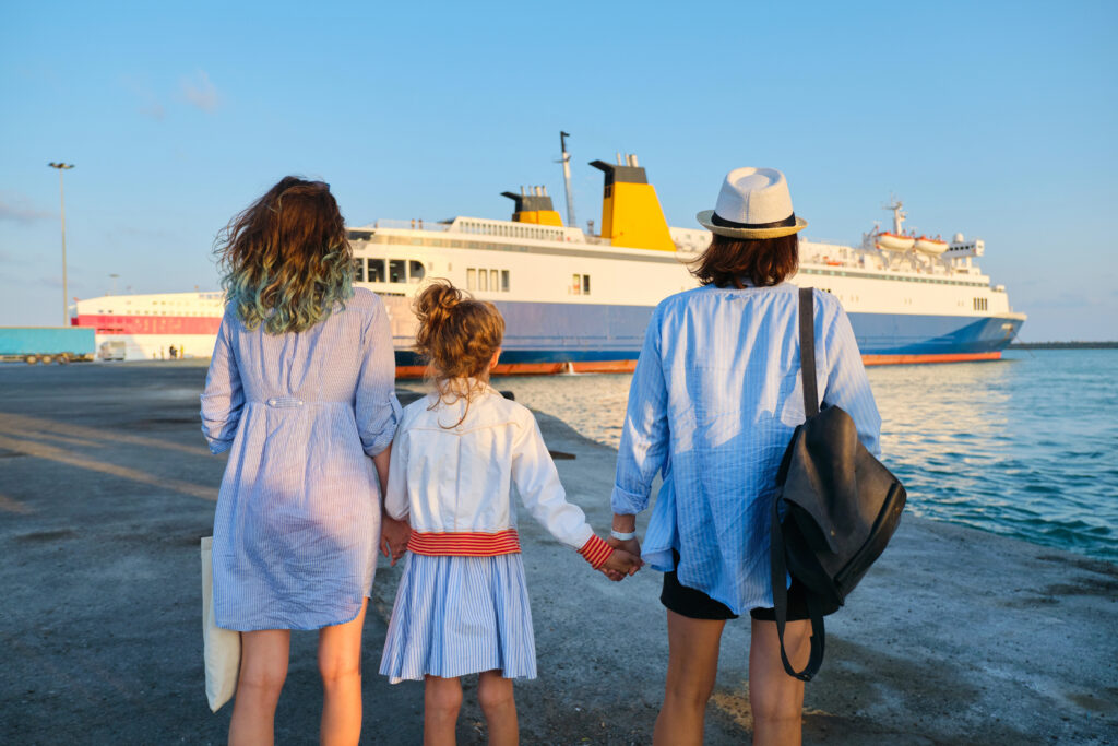 Family looking at from the shore to a small cruise ship