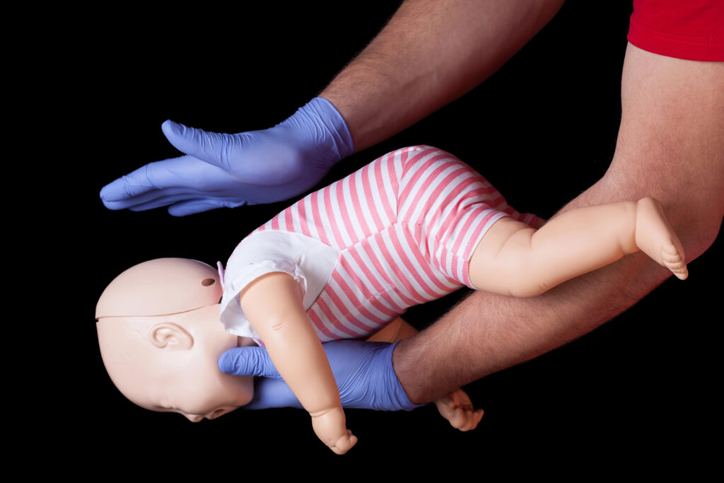 Infant first aid using an infant dummy to demonstrate