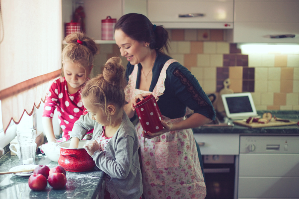 Mum in the kitchen cooking with her kids and making it fun for them.